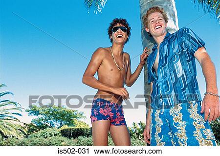 Stock Image - Young men joking by a palm tree. Fotosearch