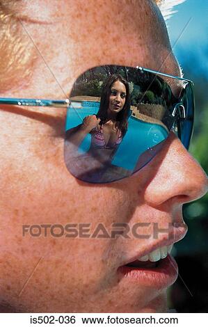 Stock Photograph - Young woman reflected in sunglasses. Fotosearch