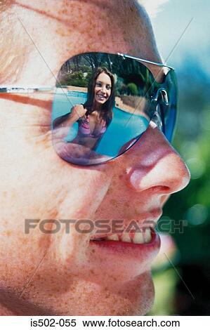 Stock Photography - Young woman reflected in sunglasses. Fotosearch