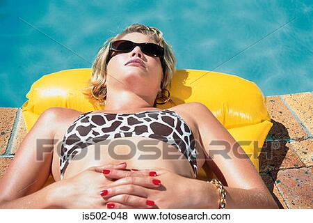 Young woman sunbathing View Large Photo Image Stock Photo - Young woman sunbathing. Fotosearch
