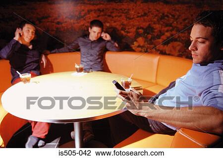 Stock Image - Friends chatting in nightclub. Fotosearch