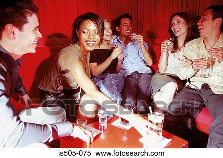 Stock Photography - Friends chatting in nightclub. Fotosearch