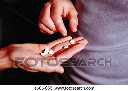 Stock Image - Male hand holding recreational drugs. Fotosearch
