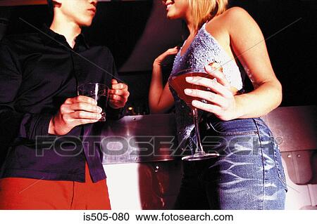 Man and woman holding drinks in nightclub View Large Photo Image Stock Image - Man and woman holding drinks in nightclub. Fotosearch