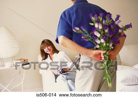 Picture - Man about to offer flowers to woman. Fotosearch