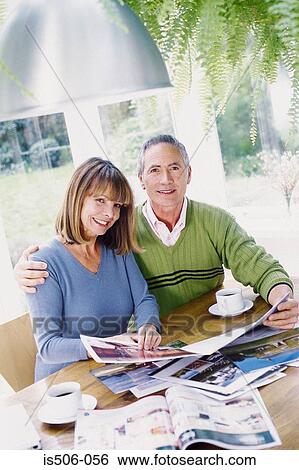 Stock Photograph - Man and woman looking at photographs. Fotosearch