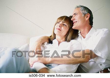 Picture - Man and woman together on sofa. Fotosearch