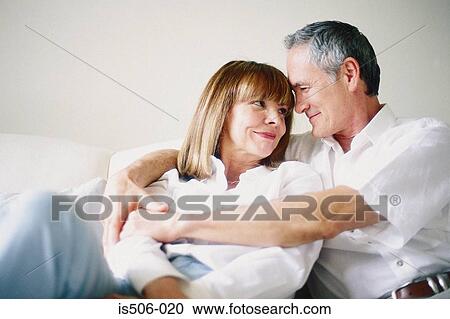 Stock Image - Man and woman together on sofa. Fotosearch