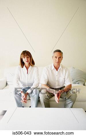 Stock Image - Man and woman together on sofa. Fotosearch
