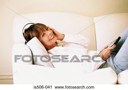 Woman listening to music on sofa View Large Photo Image Stock Image - Woman listening to music on sofa. Fotosearch