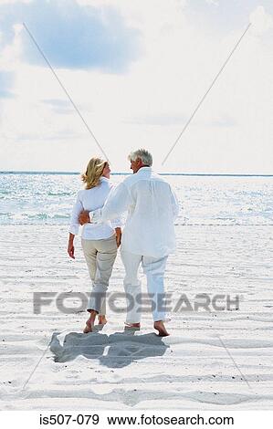 Couple walking by the sea View Large Photo Image Stock Photo - Couple walking by the sea . Fotosearch