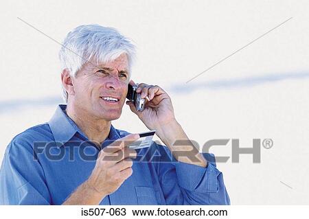 Man by the sea with cellphone and credit card View Large Photo Image Stock Image - Man by the sea with cellphone and credit card. Fotosearch