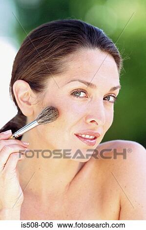 Stock Photograph - Woman applying makeup. Fotosearch