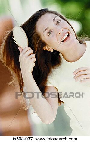 Woman brushing hair outdoors View Large Photo Image Stock Photo - Woman brushing hair outdoors. Fotosearch