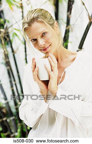 Stock Image - Woman drinking outdoors. Fotosearch