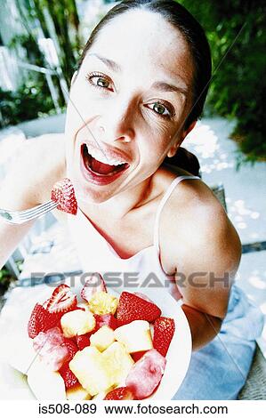 Stock Photo - Woman eating outdoors. Fotosearch