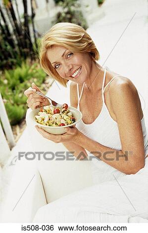 Woman eating outdoors View Large Photo Image Stock Photograph - Woman eating outdoors. Fotosearch