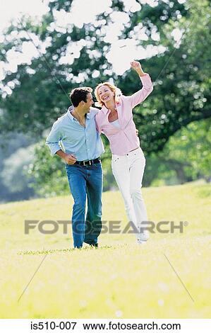 Man and woman striding through the park View Large Photo Image Stock Photo - Man and woman striding through the park. Fotosearch