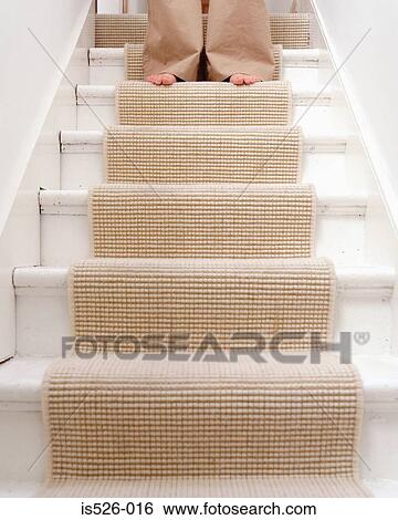 Stock Photograph - A female with bare feet coming down the stairs. Fotosearch