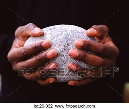 Stock Image - A man holding an oval stone. Fotosearch