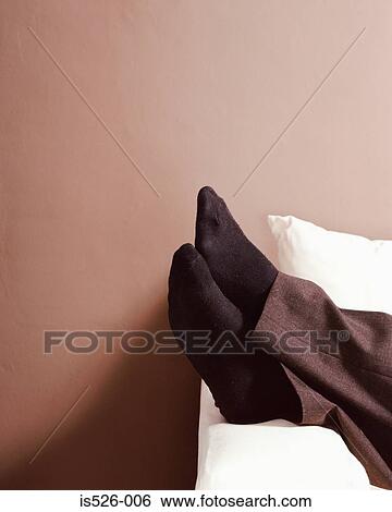 Feet resting on sofa arm View Large Photo Image Stock Photograph - Feet resting on sofa arm. Fotosearch
