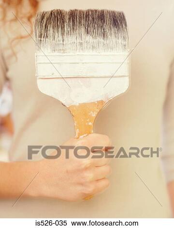Woman holding a big paint brush View Large Photo Image Stock Photography - Woman holding a big paint brush. Fotosearch