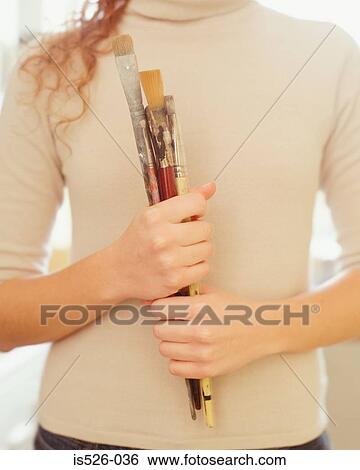 Stock Photograph - Woman holding paint brushes. Fotosearch