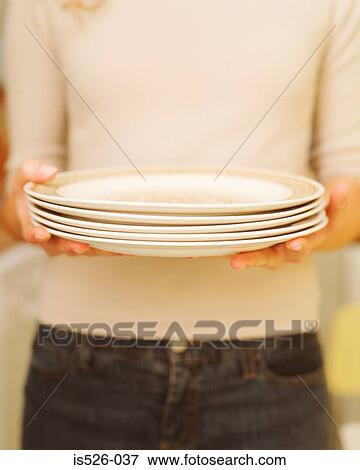 Woman holding white plates View Large Photo Image Stock Photo - Woman holding white plates. Fotosearch