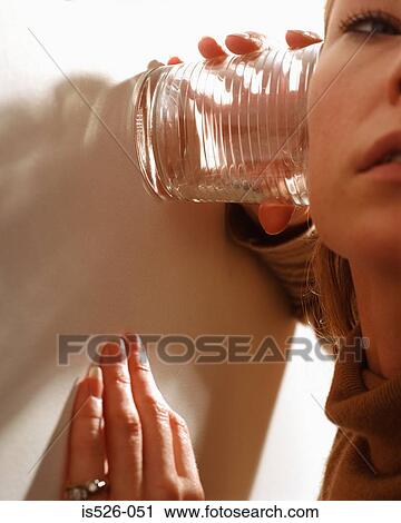 Woman trying to listen through a glass View Large Photo Image Stock Image - Woman trying to listen through a glass . Fotosearch