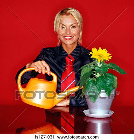 Attractive woman watering a flower View Large Photo Image Stock Image - Attractive woman watering a flower. Fotosearch