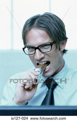 Businessman eating a chocolate bar View Large Photo Image Picture - Businessman eating a chocolate bar. Fotosearch