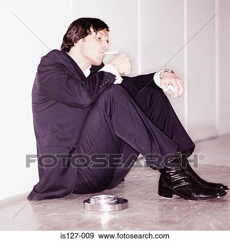 Stock Photo - Businessman lighting up a cigarette. Fotosearch