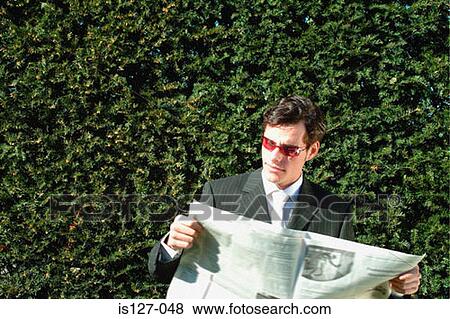 Stock Photo - Businessman reading a newspaper. Fotosearch