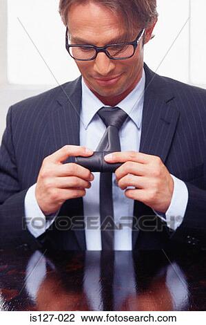 Businessman rolling-up his tie View Large Photo Image Stock Image - Businessman rolling-up his tie. Fotosearch