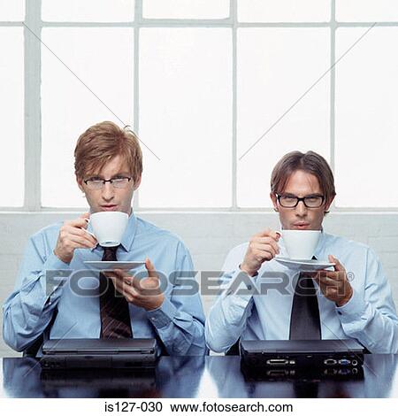 Stock Image - Two businessmen having a coffee break. Fotosearch