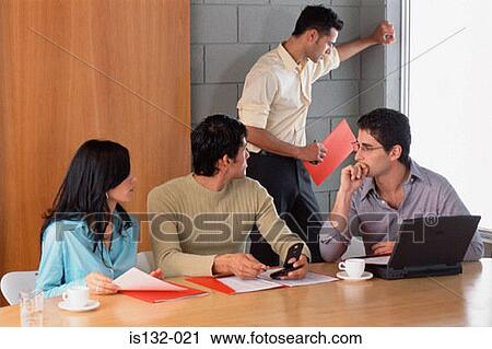 Stock Image - Businesspeople at desk. Fotosearch