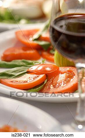 Wine glass by plate of tomatoes View Large Photo Image Stock Image - Wine glass by plate of tomatoes. Fotosearch