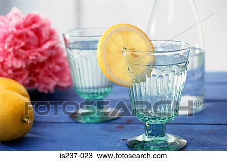 Stock Image - Slice of lemon with glass of water. Fotosearch