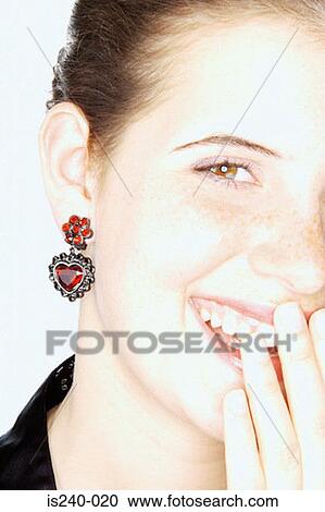 Stock Image - Laughing woman with heart shaped earring. Fotosearch