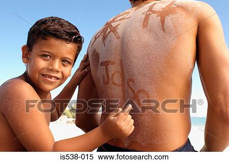 Stock Photography - Boy writing on dad's sandy back. Fotosearch