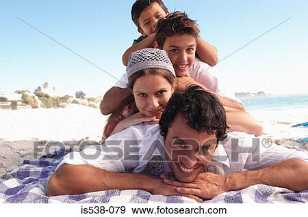 Family lying down on a beach View Large Photo Image Stock Photo - Family lying down on a beach. Fotosearch