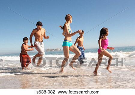 Family playing on a beach View Large Photo Image Stock Image - Family playing on a beach. Fotosearch
