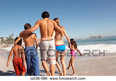 Stock Photograph - Family walking on a beach. Fotosearch