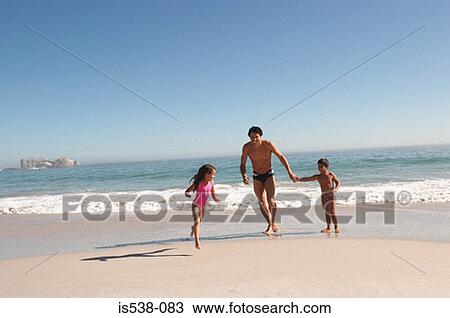 Father and children running on a beach View Large Photo Image Stock Image - Father and children running on a beach. Fotosearch