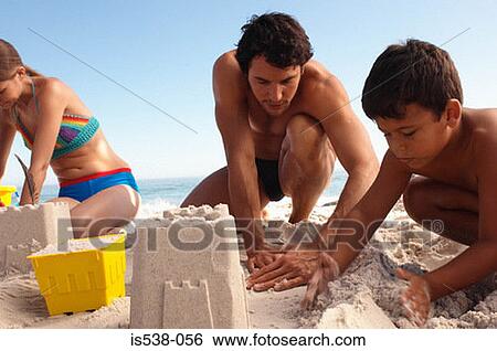 Father and son building a sandcastle View Large Photo Image Stock Photograph - Father and son building a sandcastle. Fotosearch