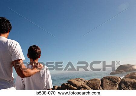 Father and son looking at the sea View Large Photo Image Stock Image - Father and son looking at the sea. Fotosearch
