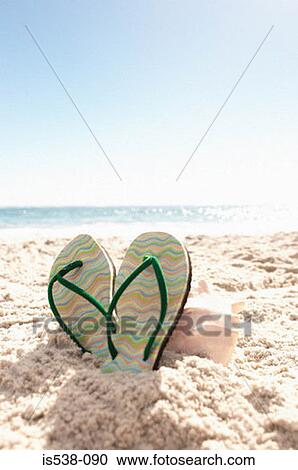 Stock Image - Flip-flops on a beach. Fotosearch