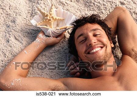 Happy man lying on a beach View Large Photo Image Stock Image - Happy man lying on a beach. Fotosearch