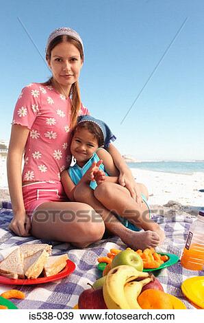 Mum and daughter having a picnic on a beach View Large Photo Image Stock Photo - Mum and daughter having a picnic on a beach. Fotosearch