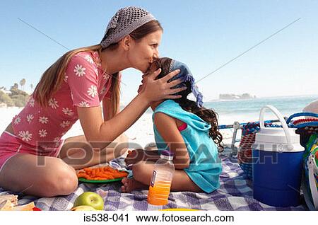 Mum kissing daughter on a beach View Large Photo Image Stock Image - Mum kissing daughter on a beach. Fotosearch